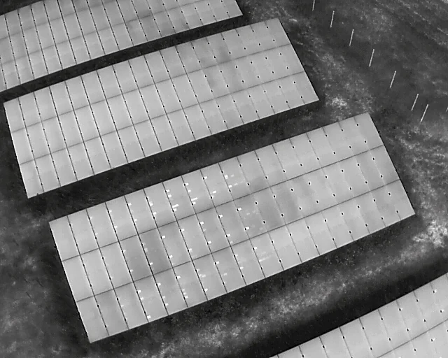 IR drone image of a PV plant with several bright thermal anomalies
